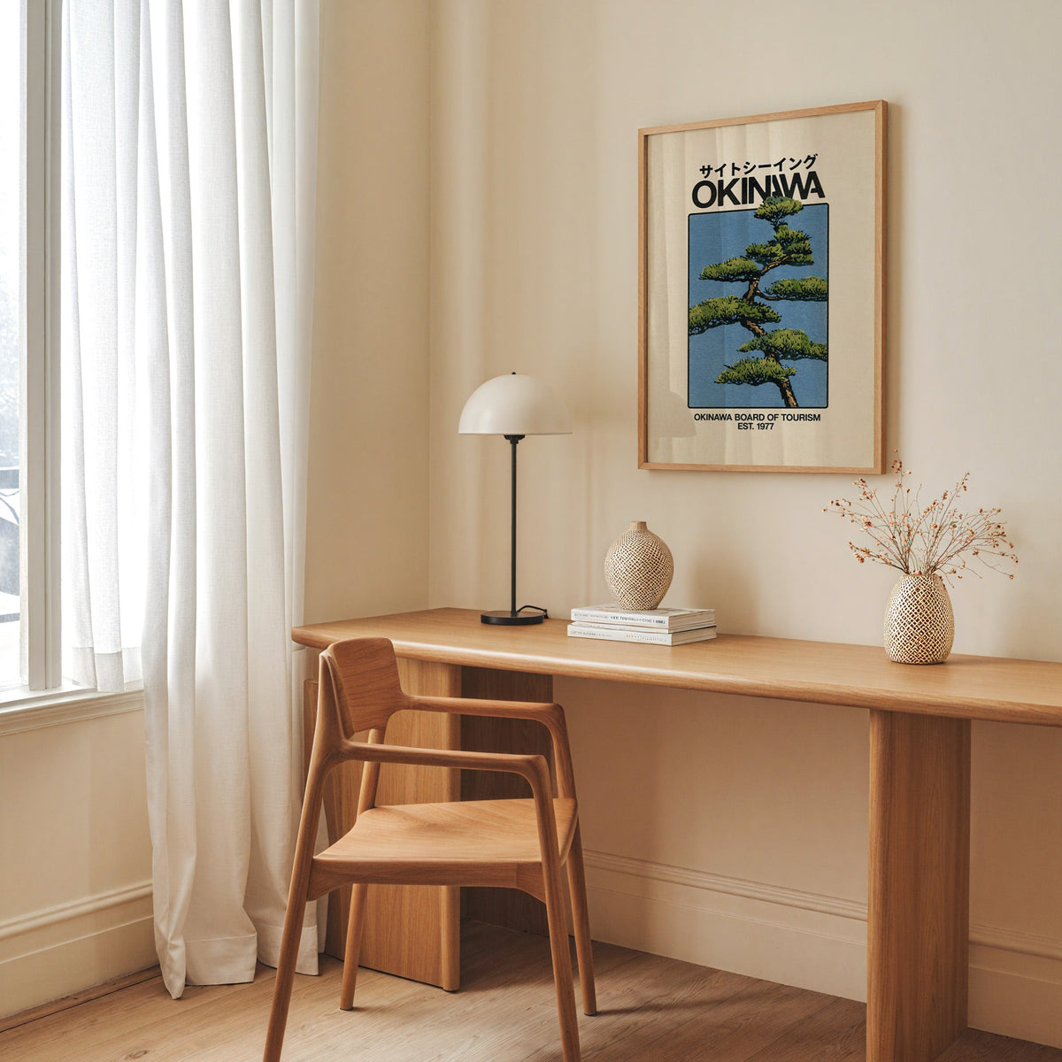 Okinawa pine tree travel poster print in an oak frame above a long oak desk with a white dome lamp and woven vases