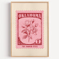 Oklahoma state flower stamp print in rose red on pink, light oak frame on a plain white wall