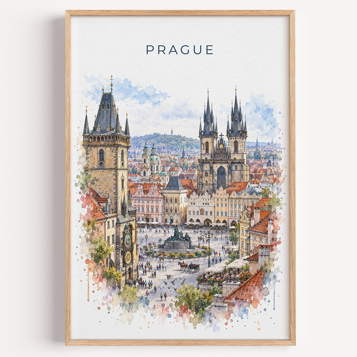 Old Town Square Prague watercolor print in a light oak frame on a plain white wall