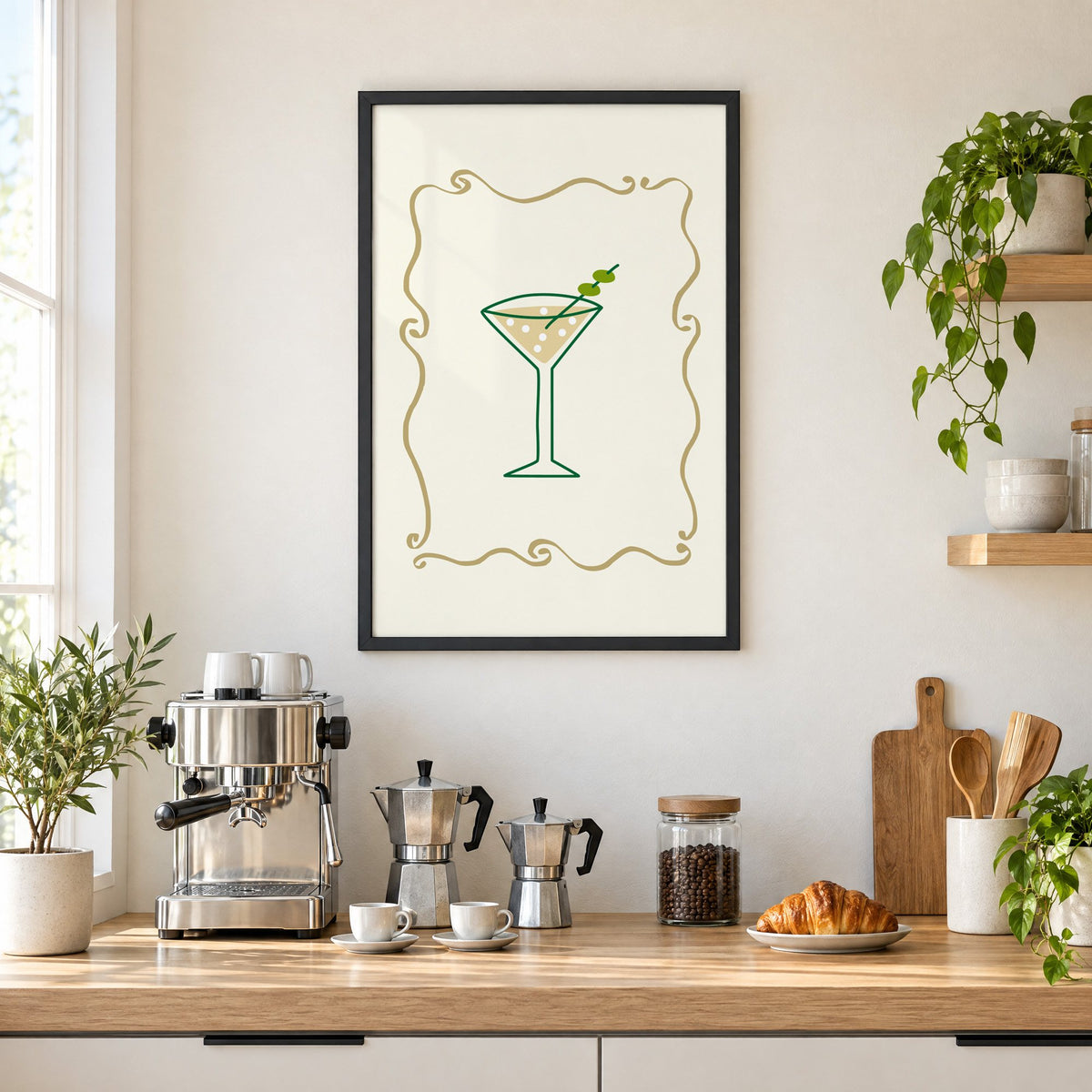 Olive martini in gold scroll frame print in a black frame above a home espresso bar with moka pots and espresso cups
