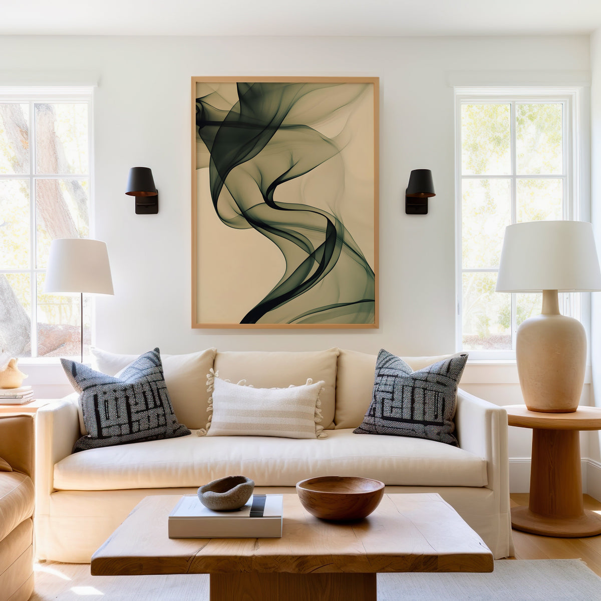 Olive smoke on cream fluid abstract print in a light oak frame above a cream sofa between two black wall sconces
