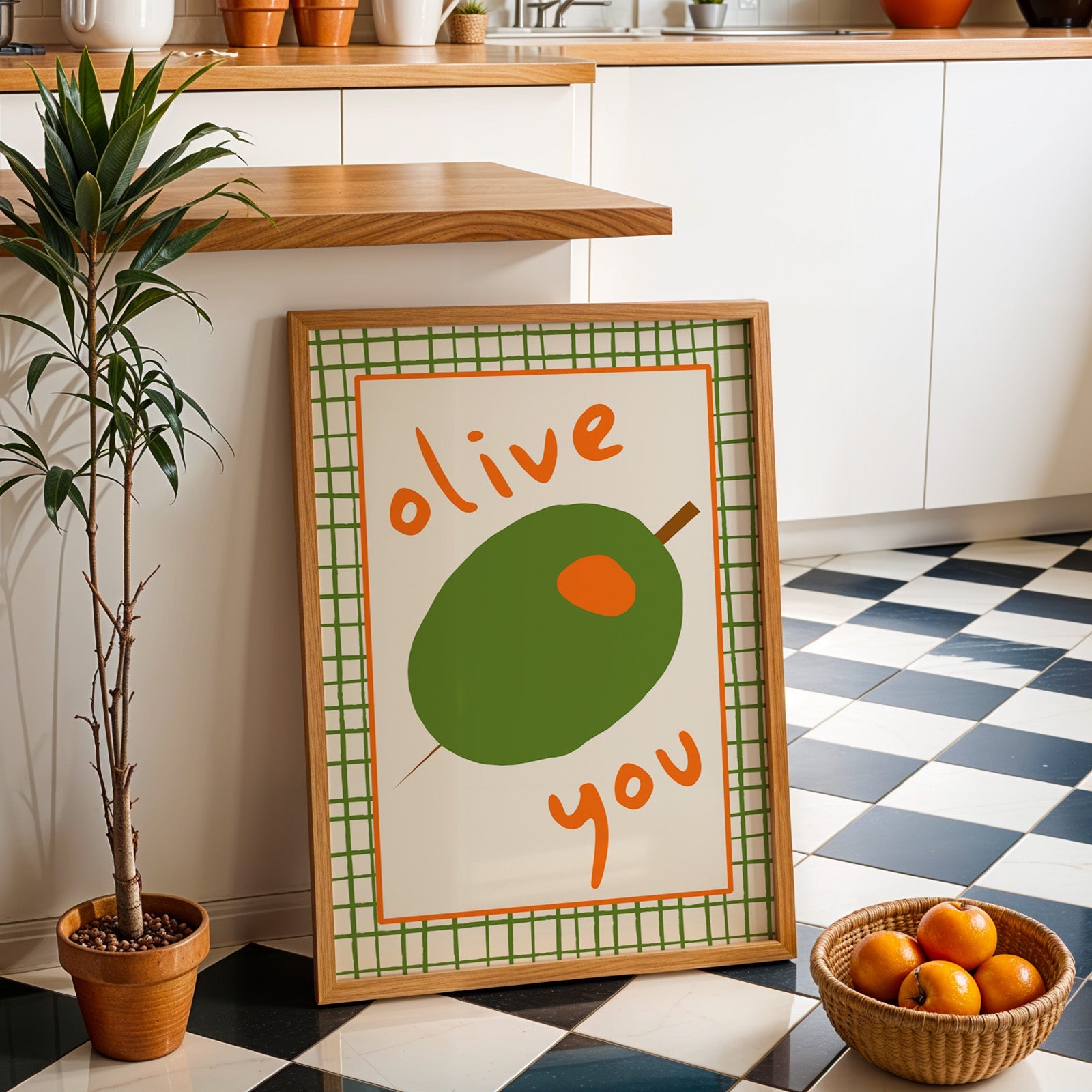 Olive you green olive print in an oak frame by a kitchen island and checkered floor