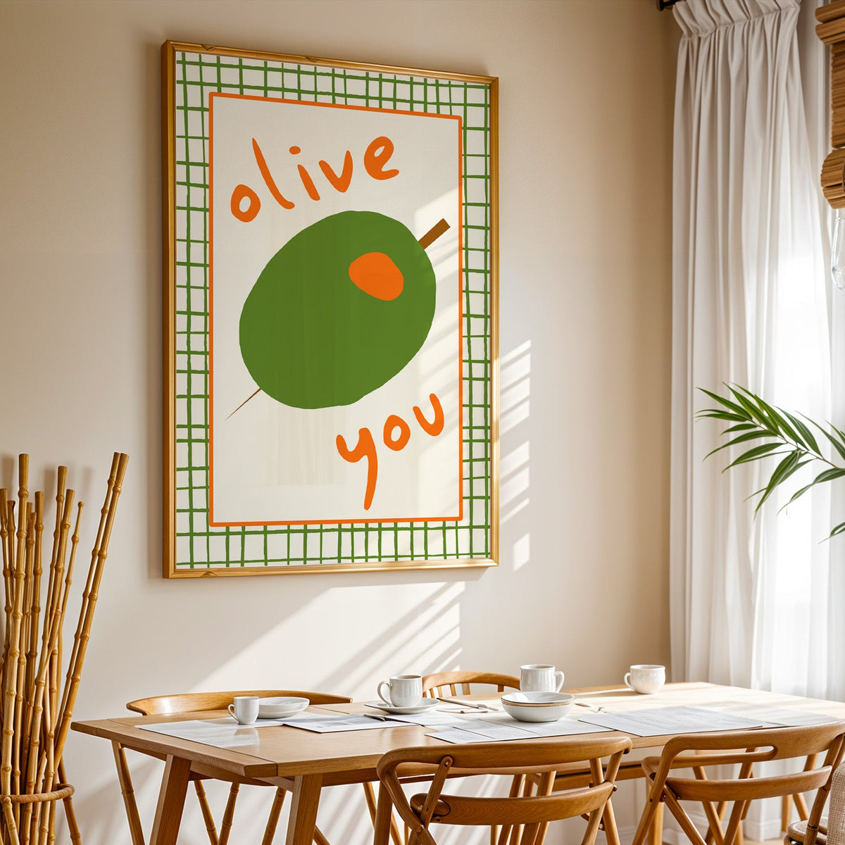 Olive you green olive print in a gold frame above a sunlit breakfast table