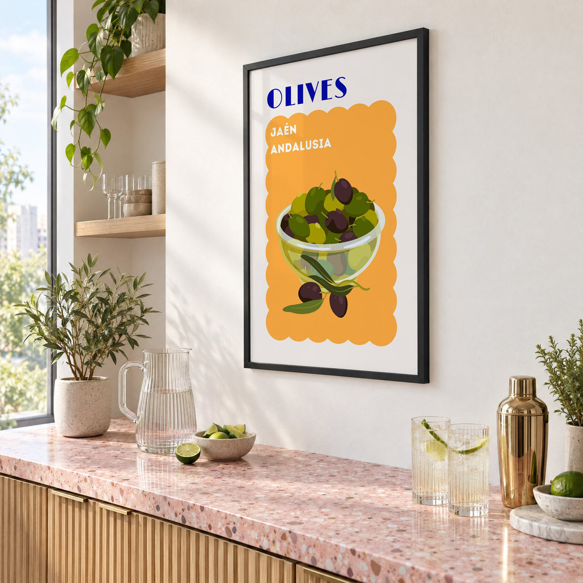 OLIVES Jaén Andalusia orange print in a black frame above a pink terrazzo cocktail counter with limes, seen at an angle
