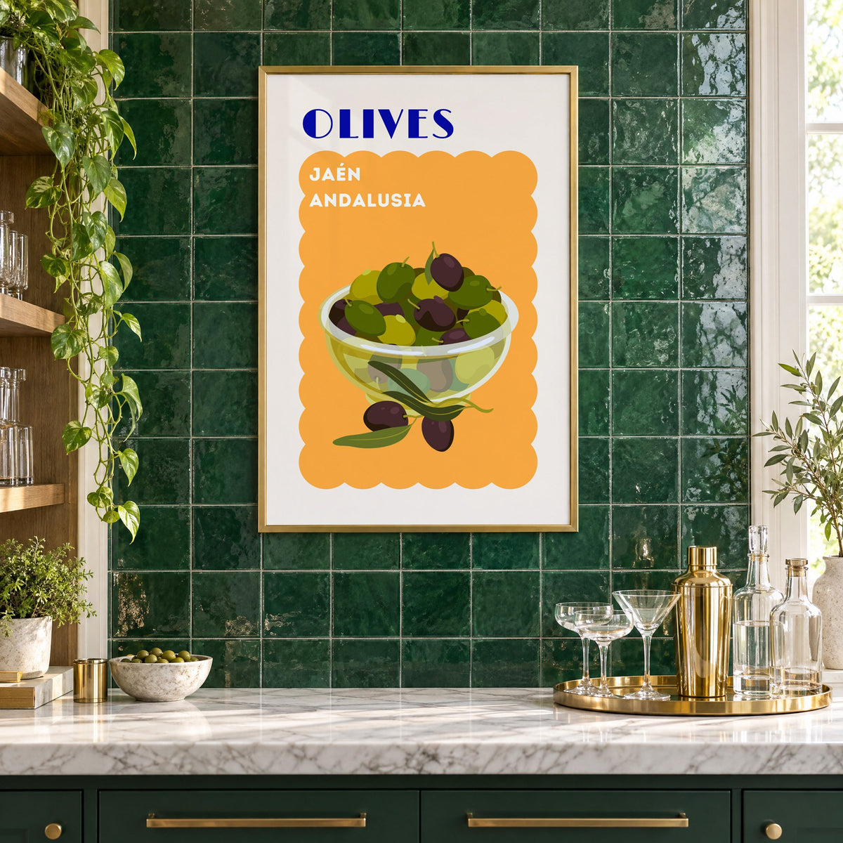 OLIVES Jaén Andalusia orange print in a brass frame on emerald green tiles above a home bar with coupe glasses