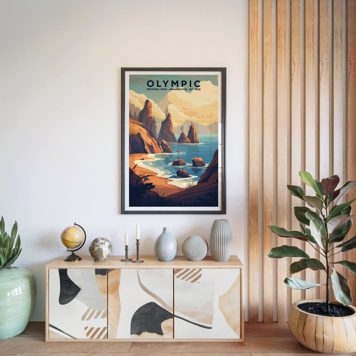 Olympic National Park print in a black frame above a light wood sideboard with a globe and ceramic vases