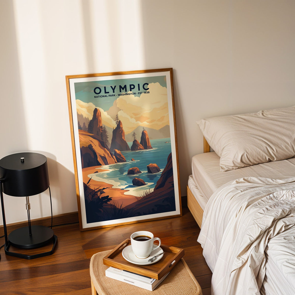 Olympic National Park print in an oak frame leaning on a bedroom floor beside the bed and a coffee tray