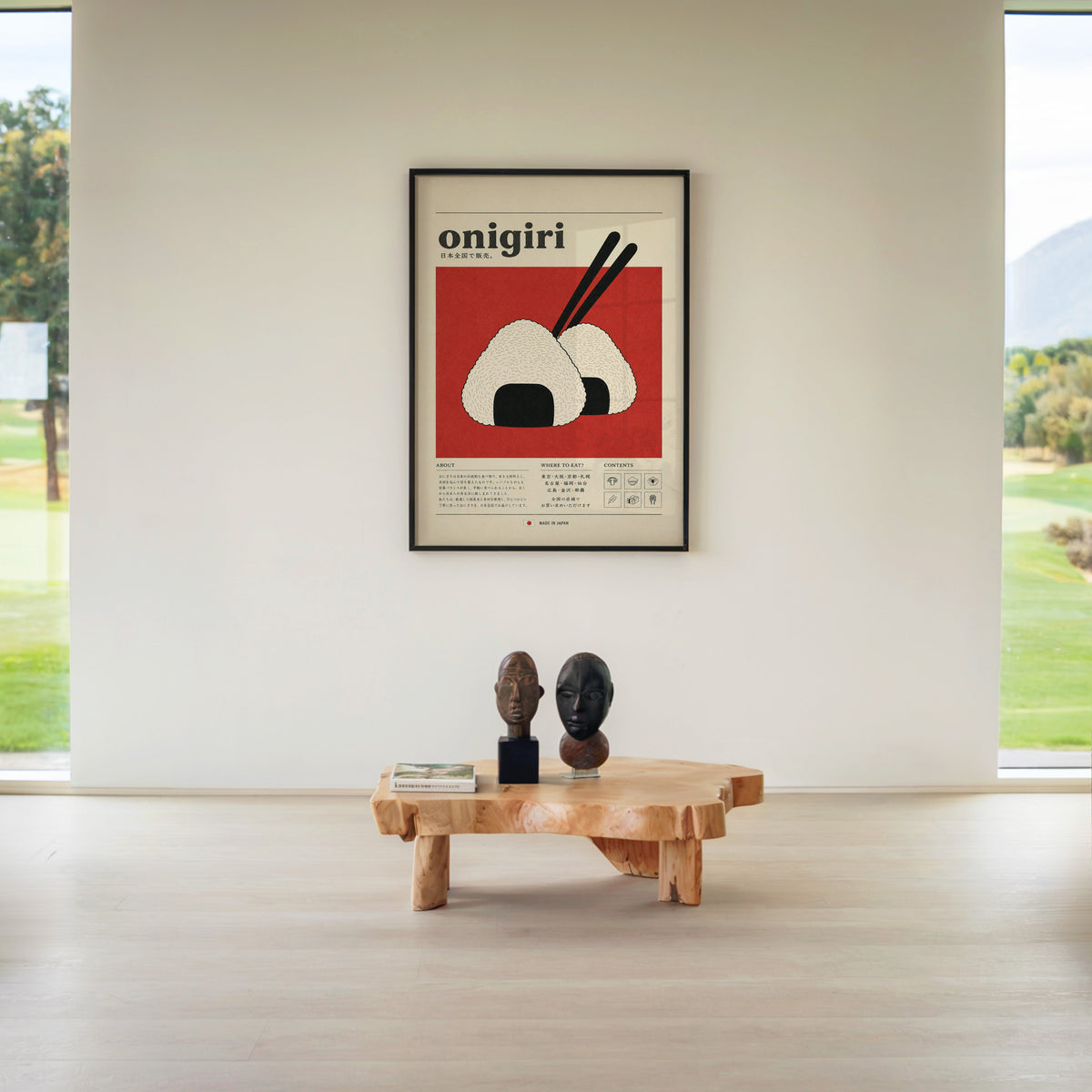 onigiri rice balls on red print in a black frame above a live-edge wood coffee table between garden windows