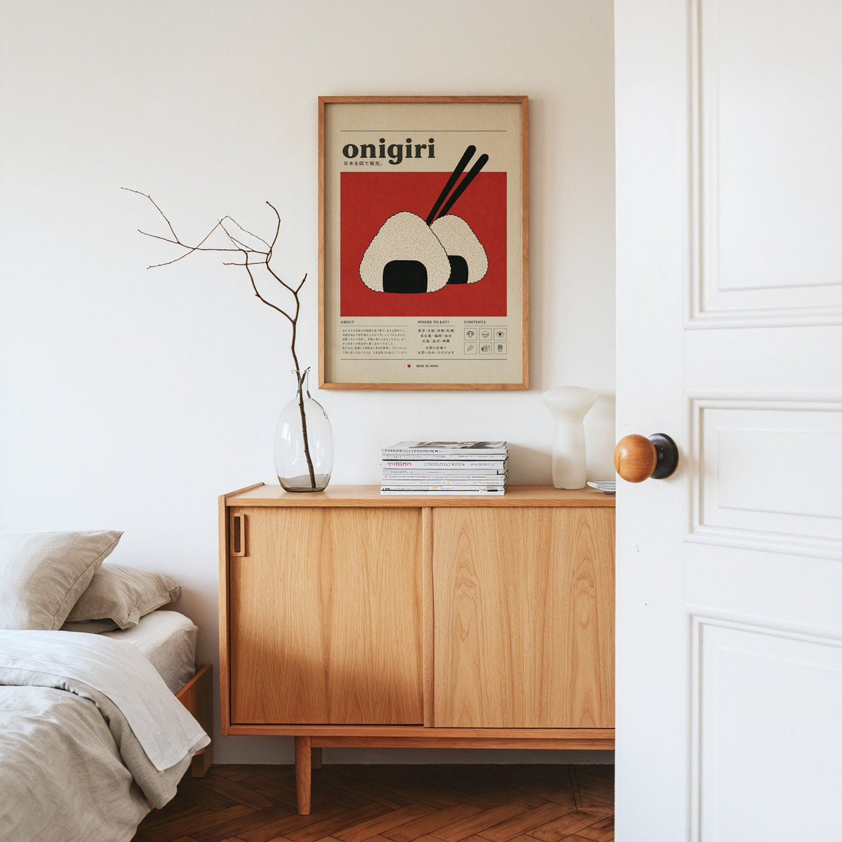 onigiri rice balls on red print in an oak frame above an oak sideboard in a bedroom with linen bedding