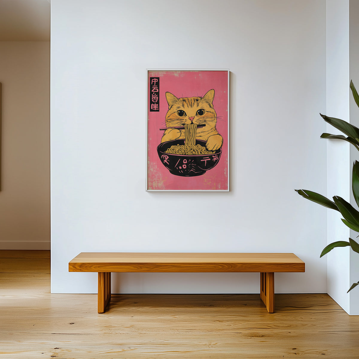 Orange tabby cat slurping ramen print shown in a white frame above a wooden entryway bench