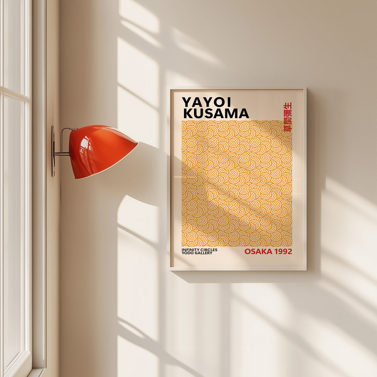 Yayoi Kusama inspired orange concentric circle print in a white frame by a red wall lamp
