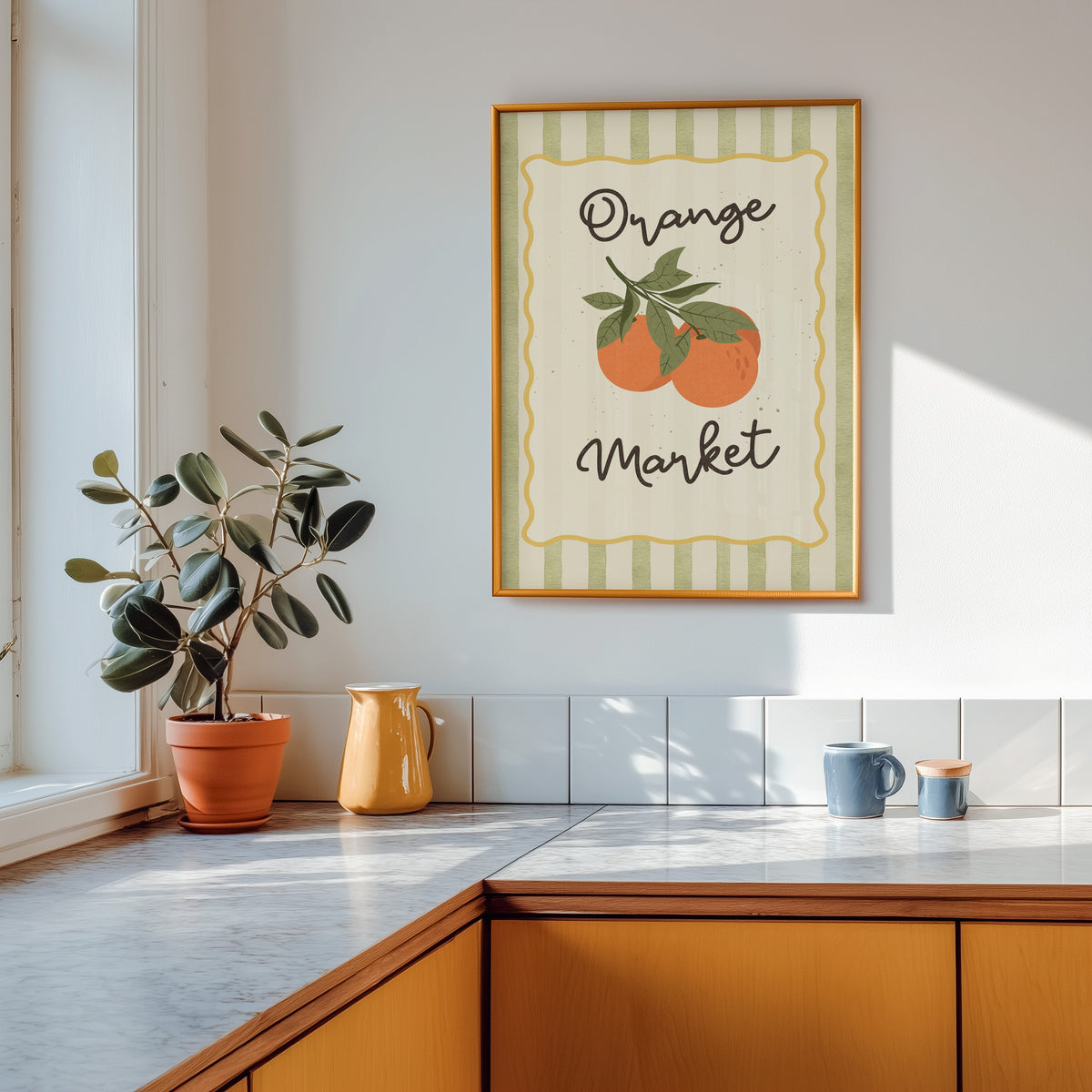 Orange Market print shown in a gold frame above a marble counter in a tan kitchen