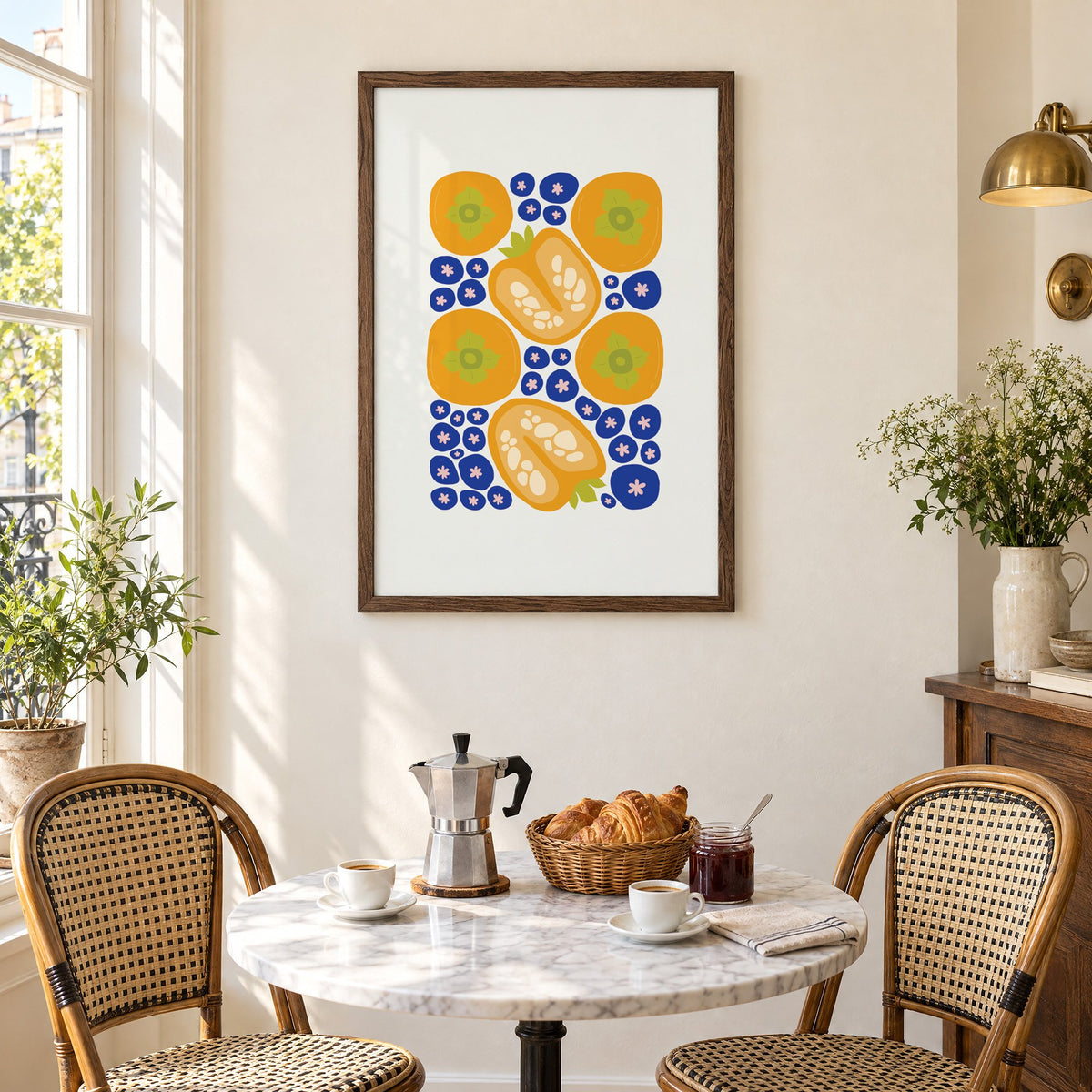 orange persimmons cobalt blueberries pattern print in a walnut frame above a marble bistro table with croissants and rattan chairs