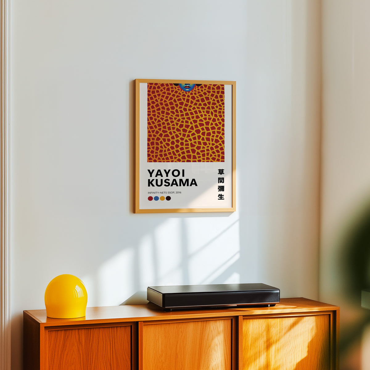 Yayoi Kusama inspired orange net and lips print above a sideboard with a yellow lamp