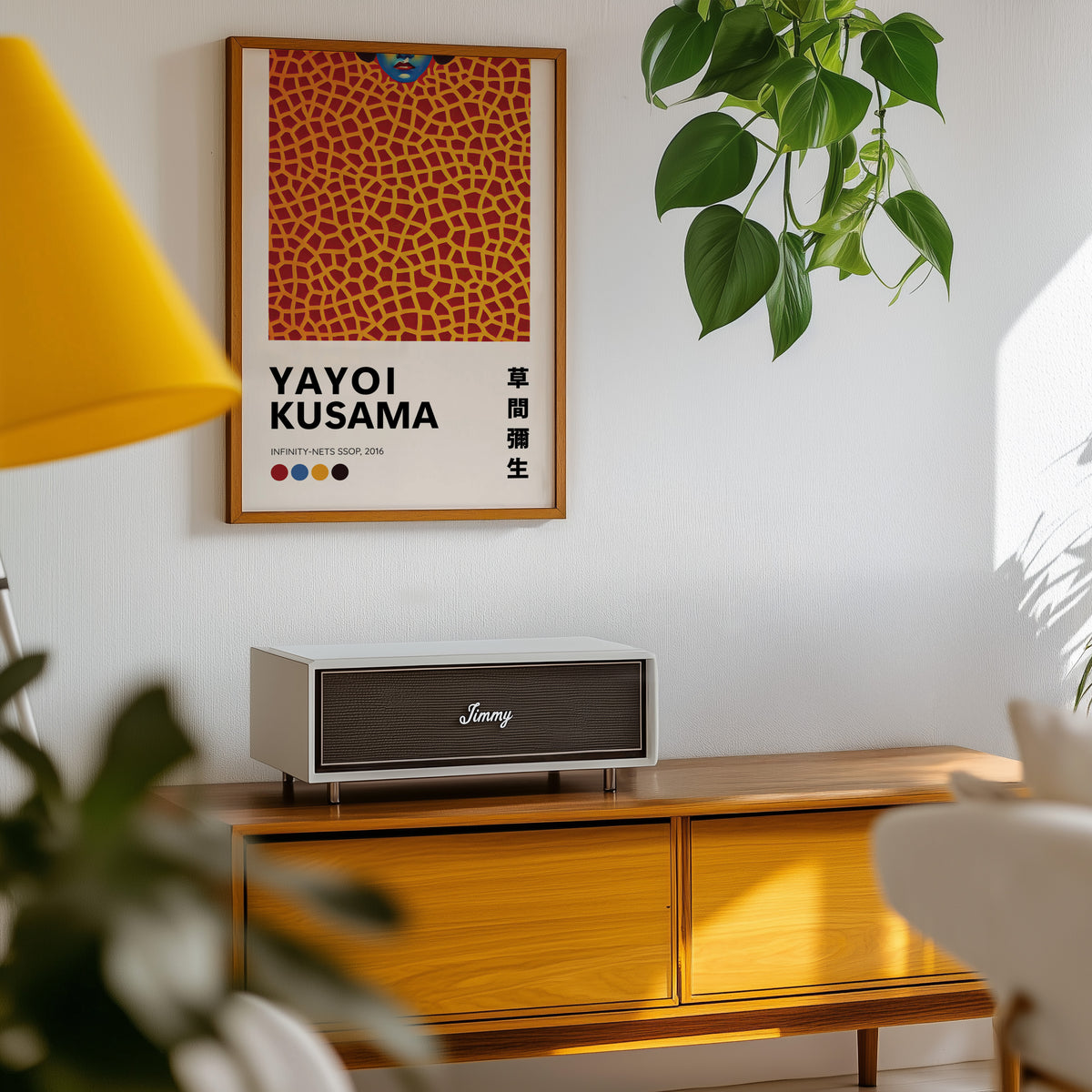 Yayoi Kusama inspired orange net and lips print above a sideboard with a plant