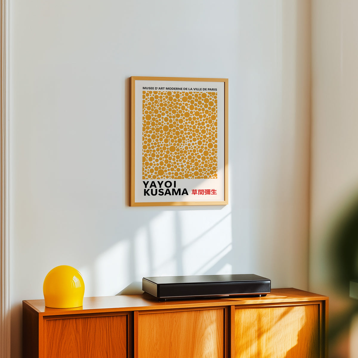 Yayoi Kusama inspired orange polka dot pattern print above a sideboard with a yellow lamp