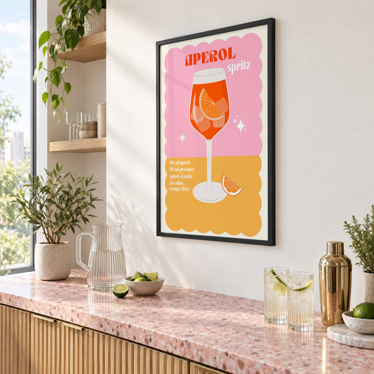 Orange spritz scalloped pink print in a black frame above a pink terrazzo cocktail counter with limes, seen at an angle