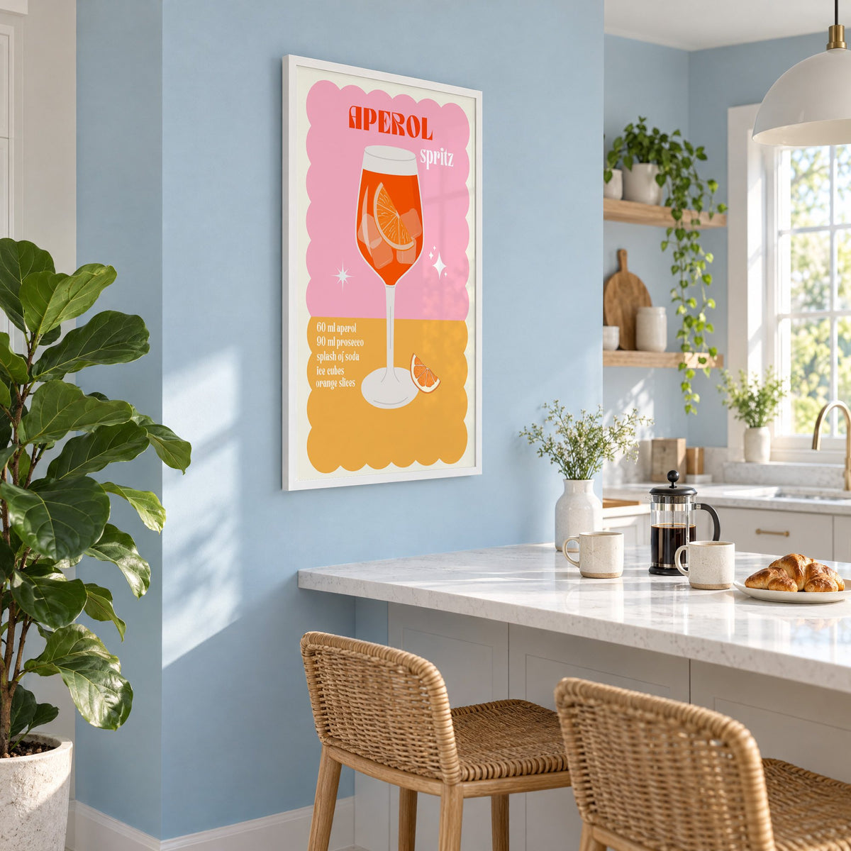 Orange spritz scalloped pink print in a white frame on a pale blue wall above a breakfast bar with rattan stools