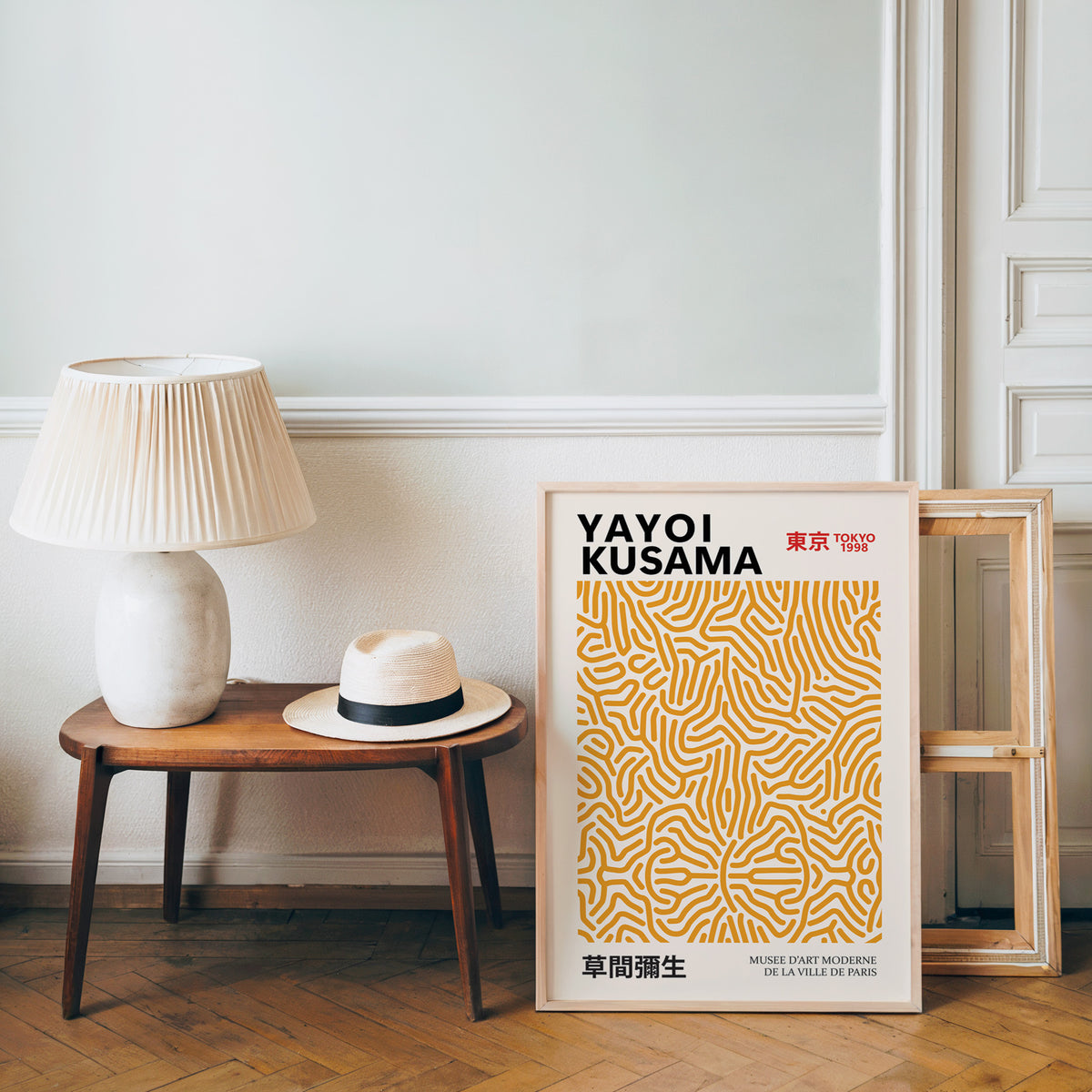 Yayoi Kusama inspired orange squiggle pattern print beside a bench and straw hat