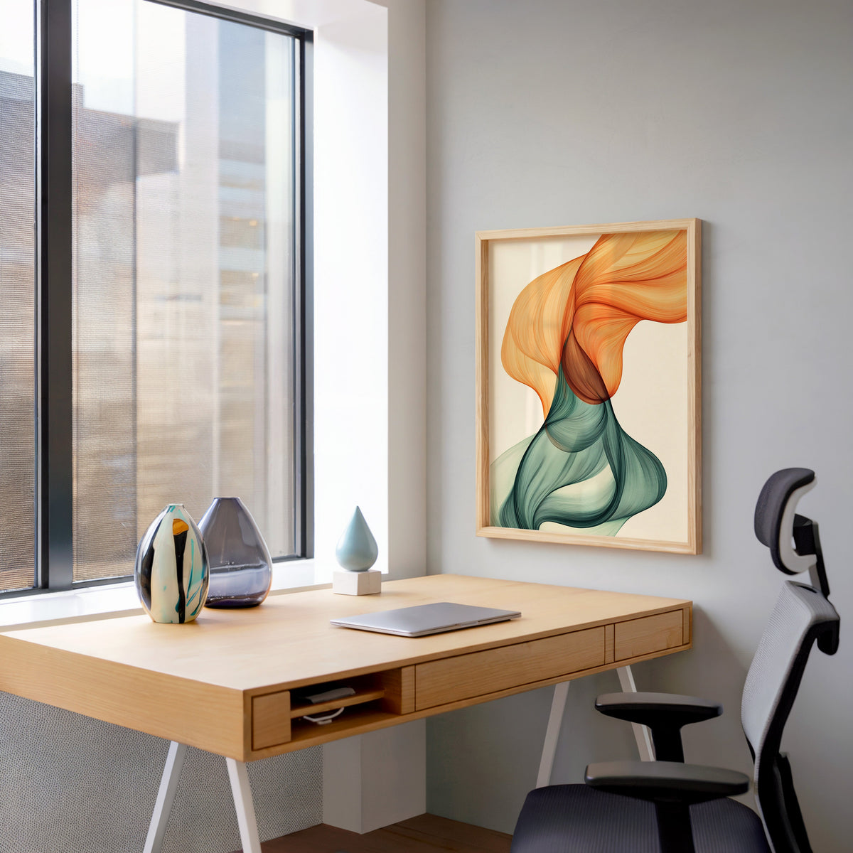 Orange and teal silk ribbon fluid abstract print in a pale wood frame above a home office desk by a tall window