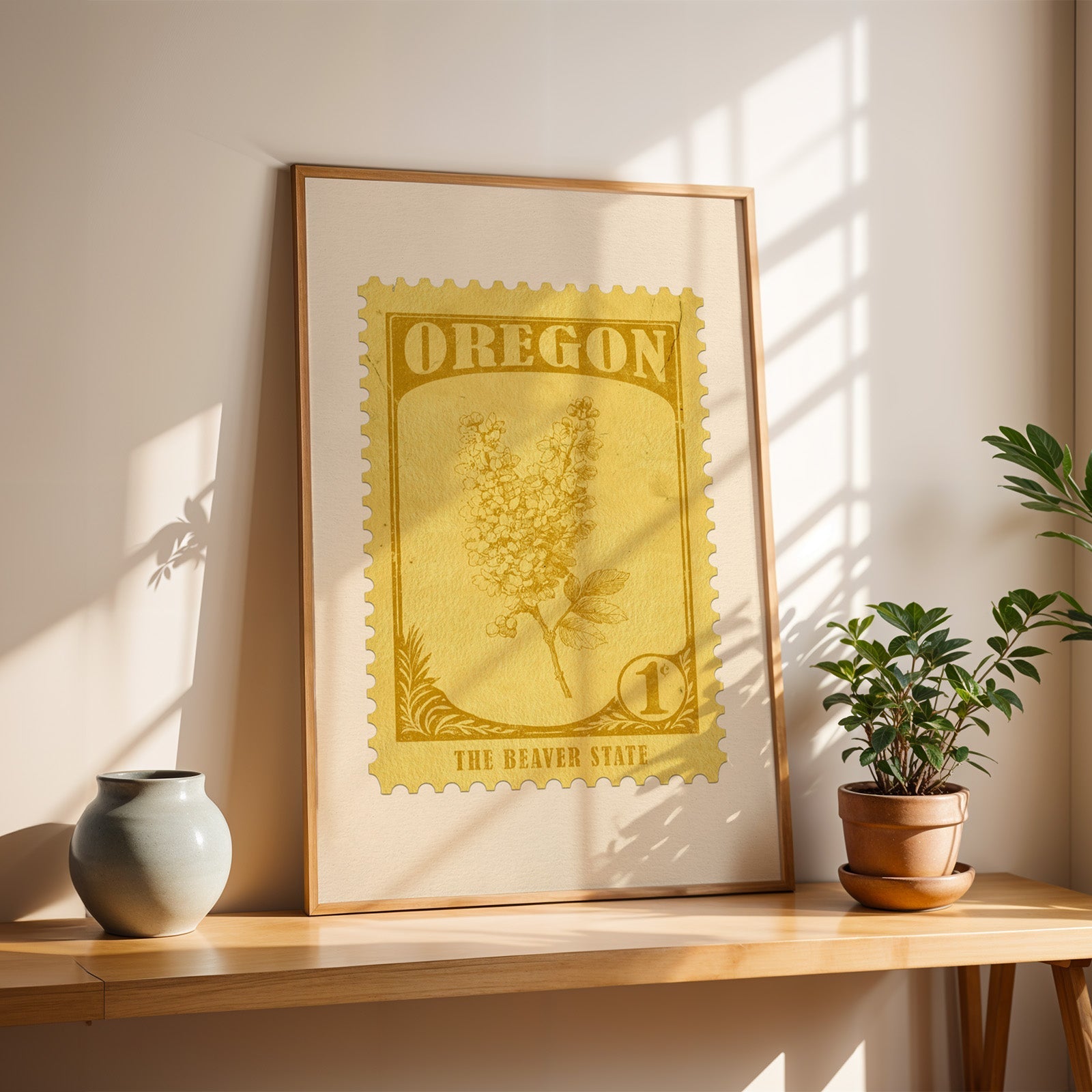 Oregon Grape stamp print in a light oak frame leaning on a wooden table beside a stoneware vase
