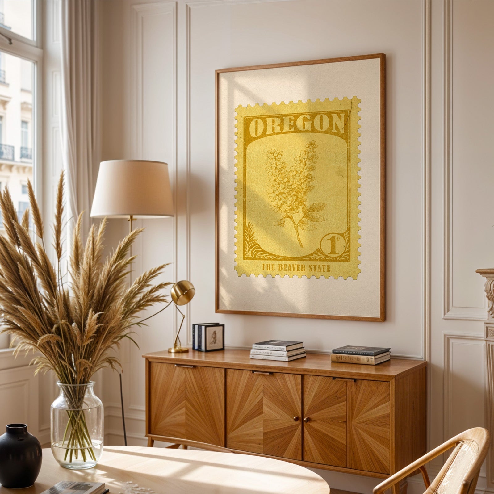 Oregon stamp print framed above a wooden sideboard, pampas grass in a glass vase and a floor lamp