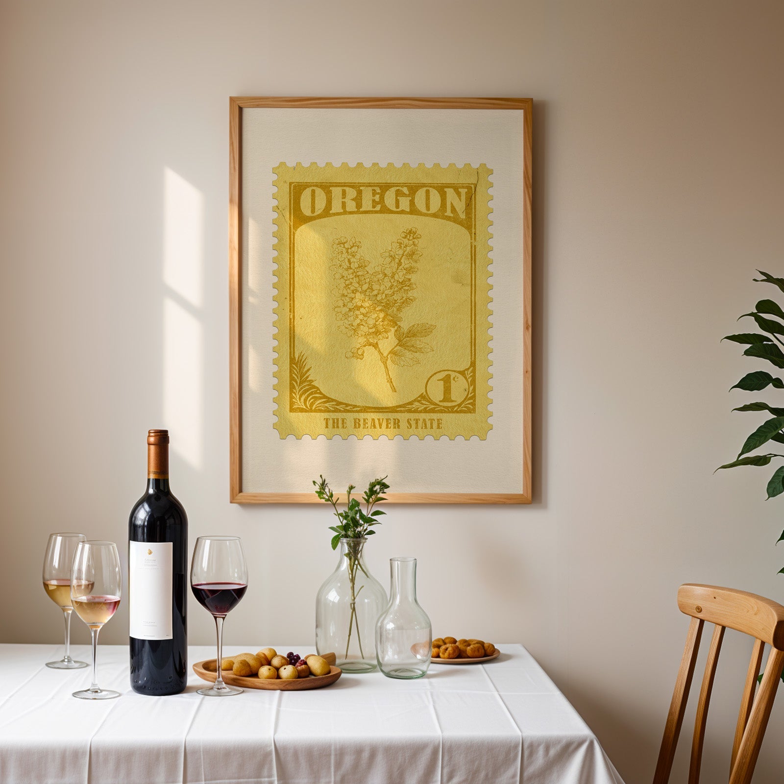 Oregon stamp print framed on the wall above a dining table set with wine, glasses and olives
