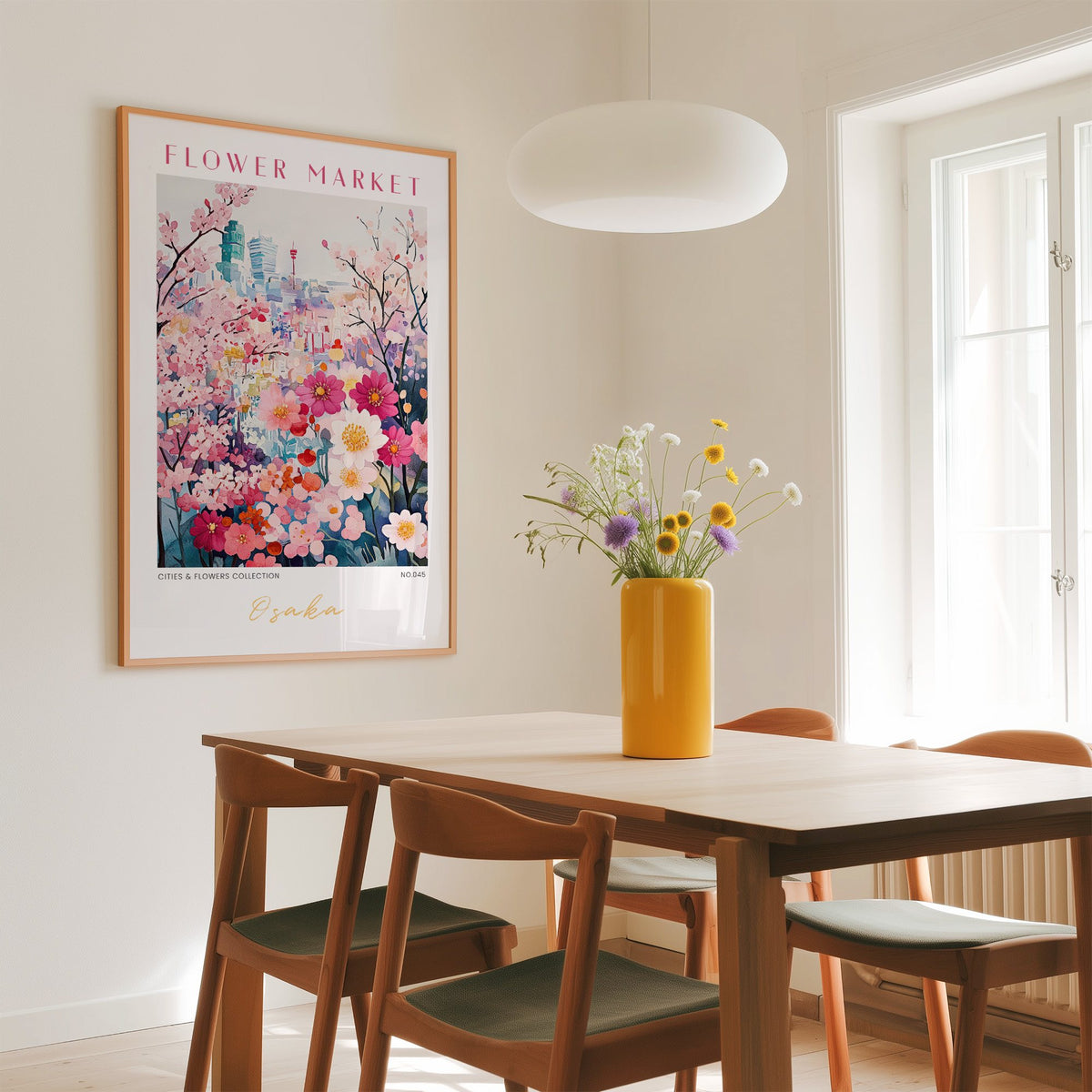 Osaka flower market print in an oak frame above a dining table with a yellow vase and white pendant light