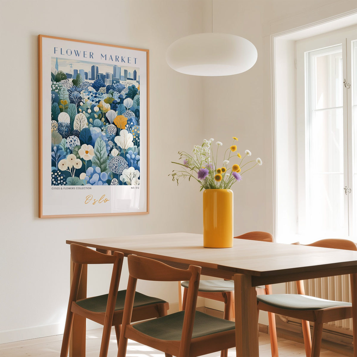 Oslo flower market print in an oak frame above a dining table with a yellow vase and white pendant light