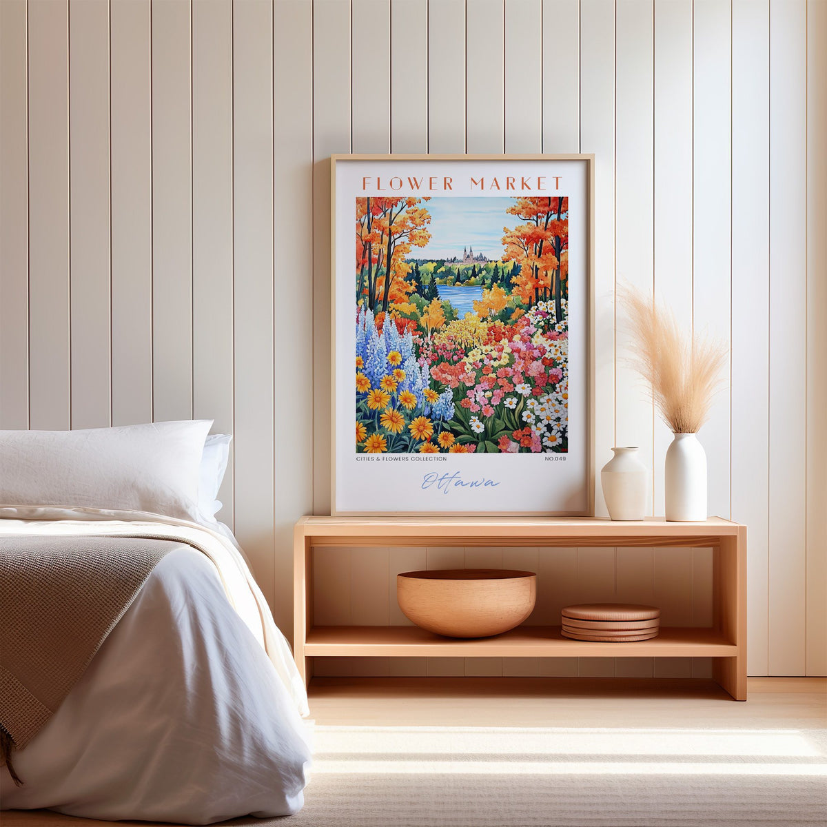 Ottawa flower market print in an oak frame on a wood bench against a white shiplap bedroom wall with pampas grass