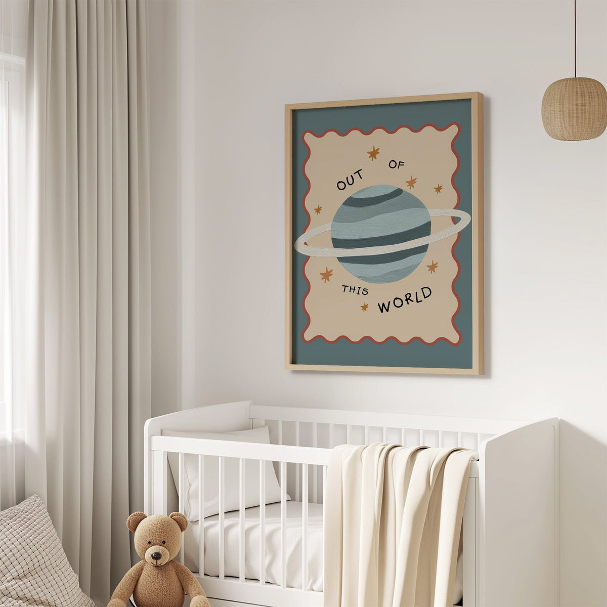 Out of this world planet nursery print in an oak frame above a white crib with a teddy bear