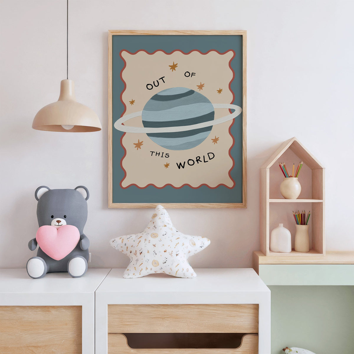Out of this world planet nursery print in an oak frame above a white dresser with a star pillow and house shelf