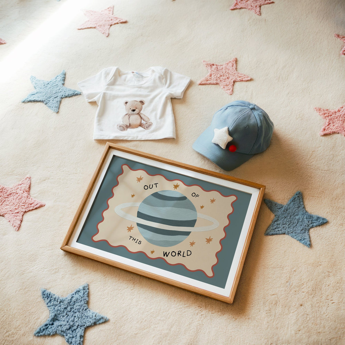 Landscape out of this world planet nursery print in a matted oak frame on a star rug with a baby tee