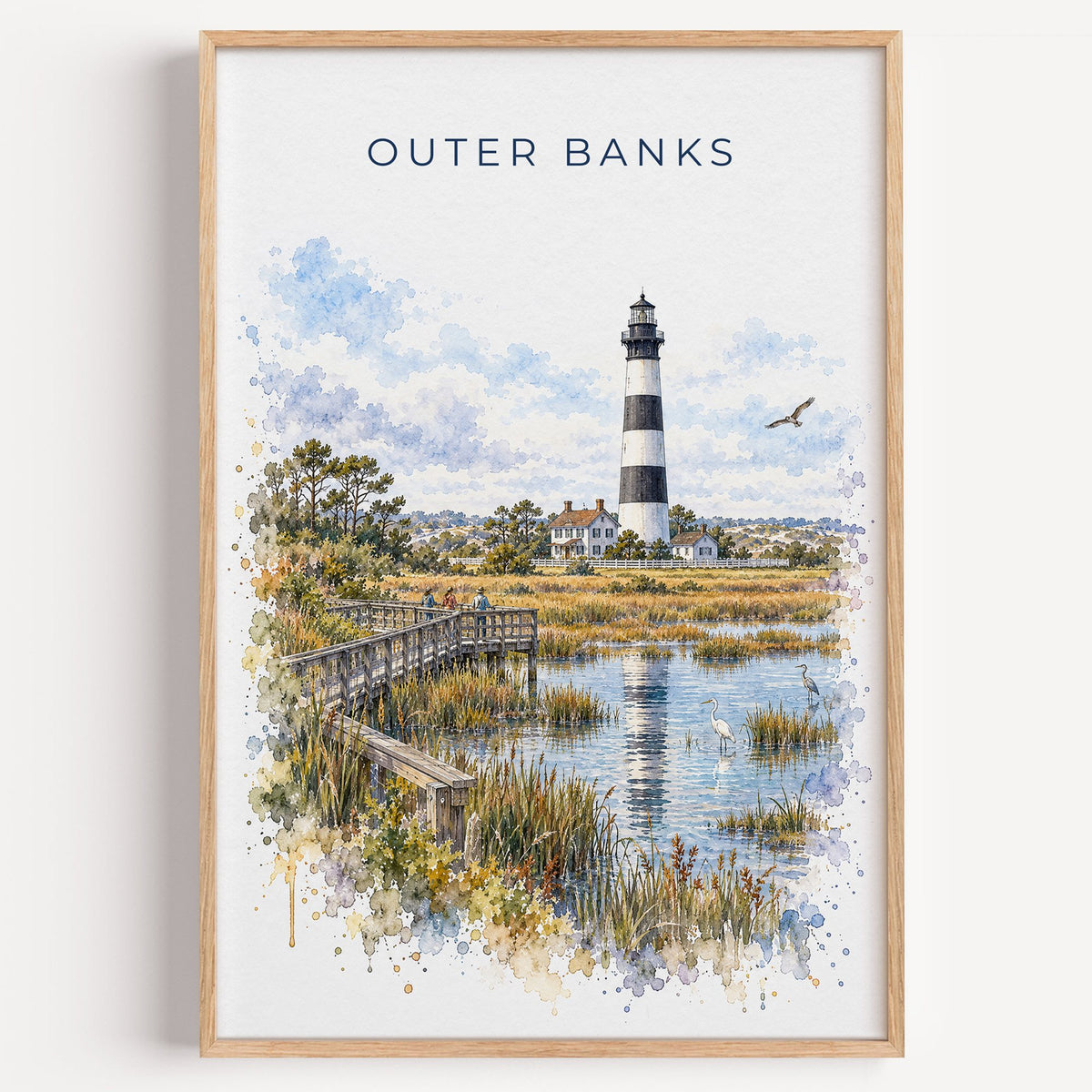 Outer Banks watercolor print in a light oak frame on a plain white wall