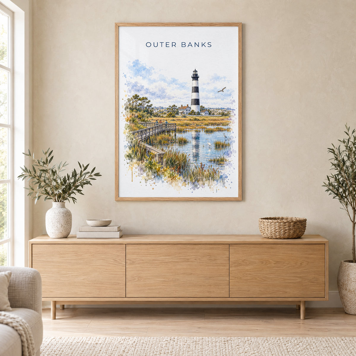 Outer Banks watercolor print in an oak frame above a light wood sideboard in a Scandinavian living room