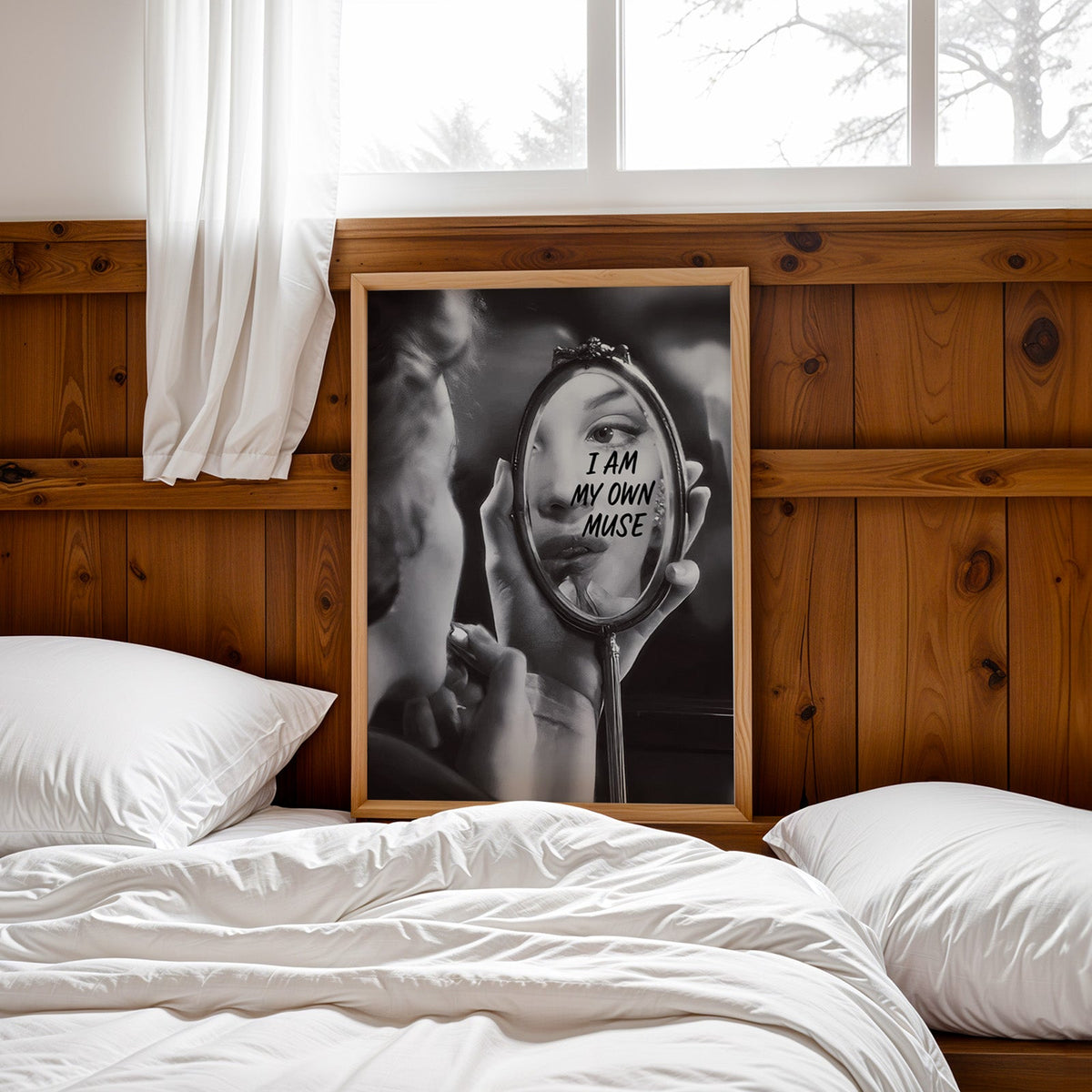 I am my own muse hand mirror portrait print in a pine frame leaning on a wood headboard over white bedding