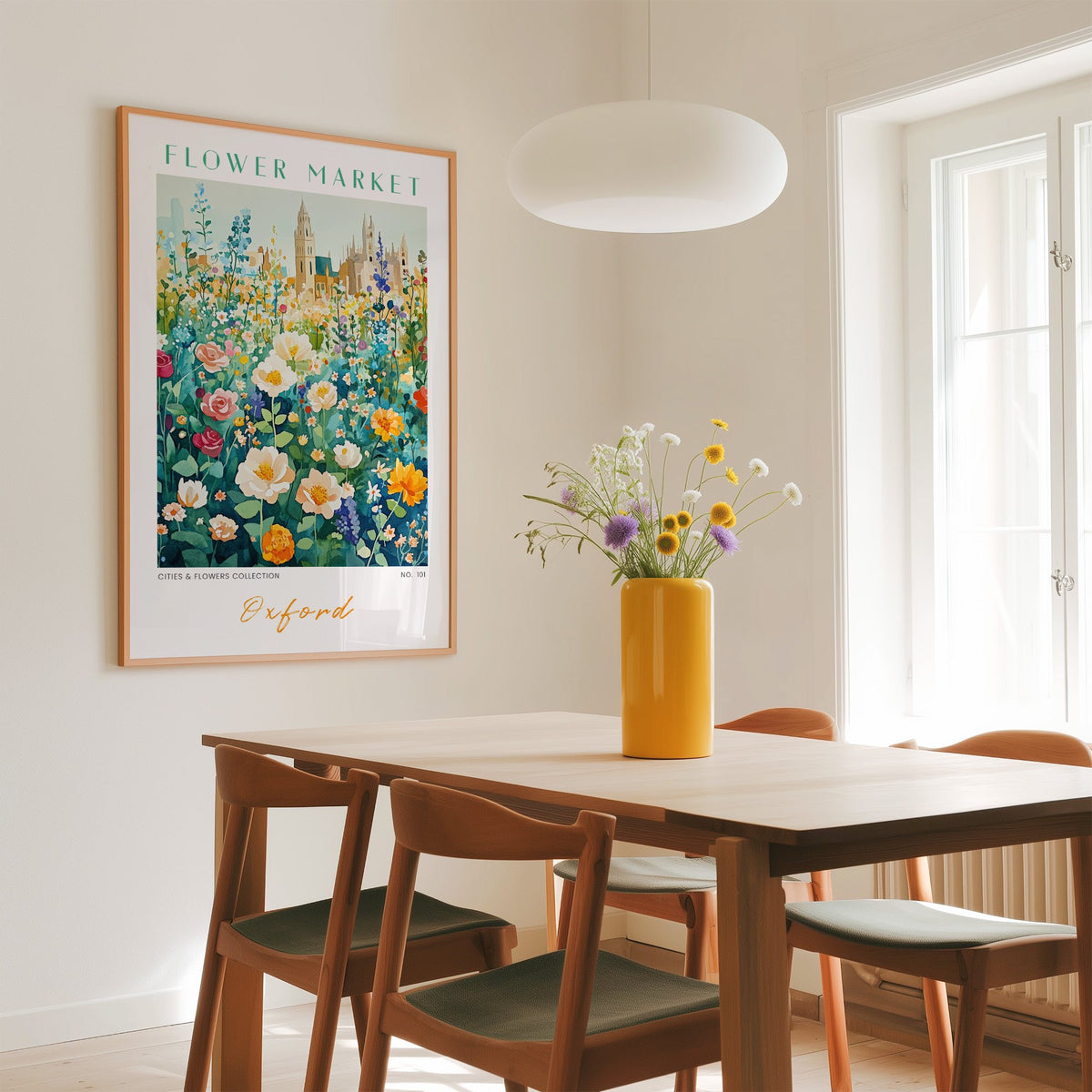 Oxford flower market print in an oak frame above a dining table with a yellow vase and white pendant light