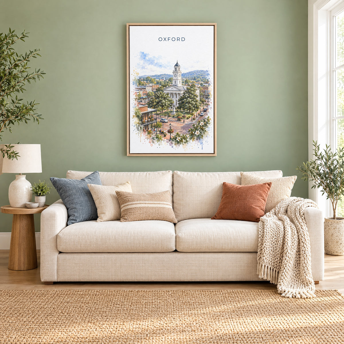 Oxford, Mississippi watercolor print as a natural floater canvas above a cream linen sofa on a sage green wall