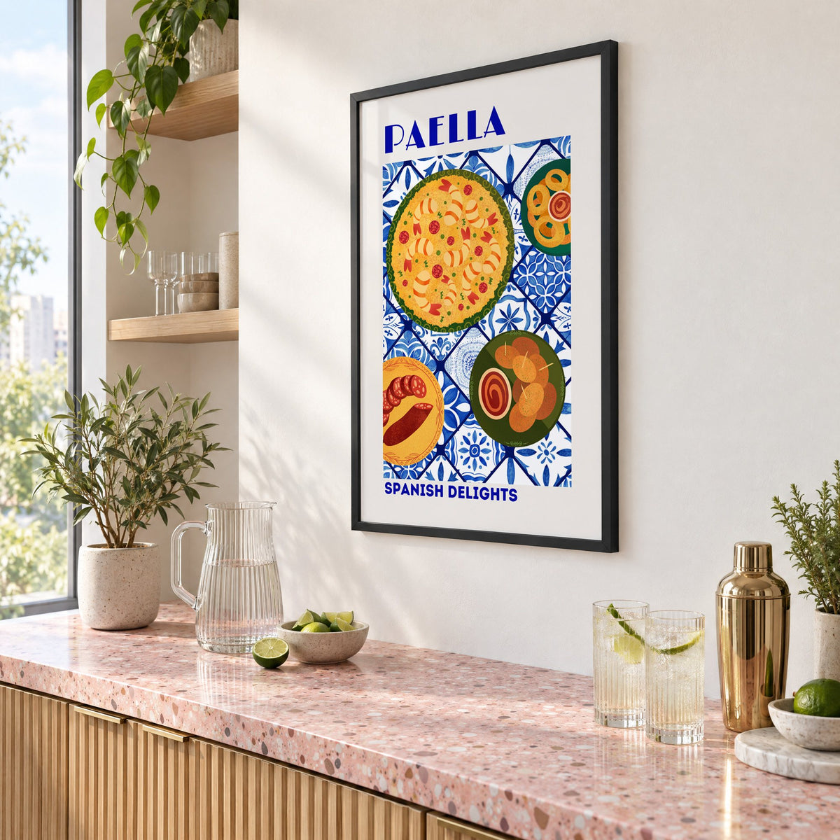 PAELLA Spanish Delights blue tile print in a black frame above a pink terrazzo cocktail counter with limes, seen at an angle
