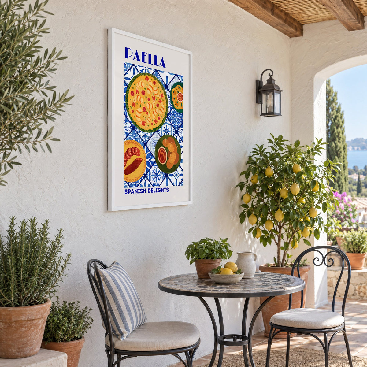 PAELLA Spanish Delights blue tile print in a white frame on a sunny patio wall beside a potted lemon tree