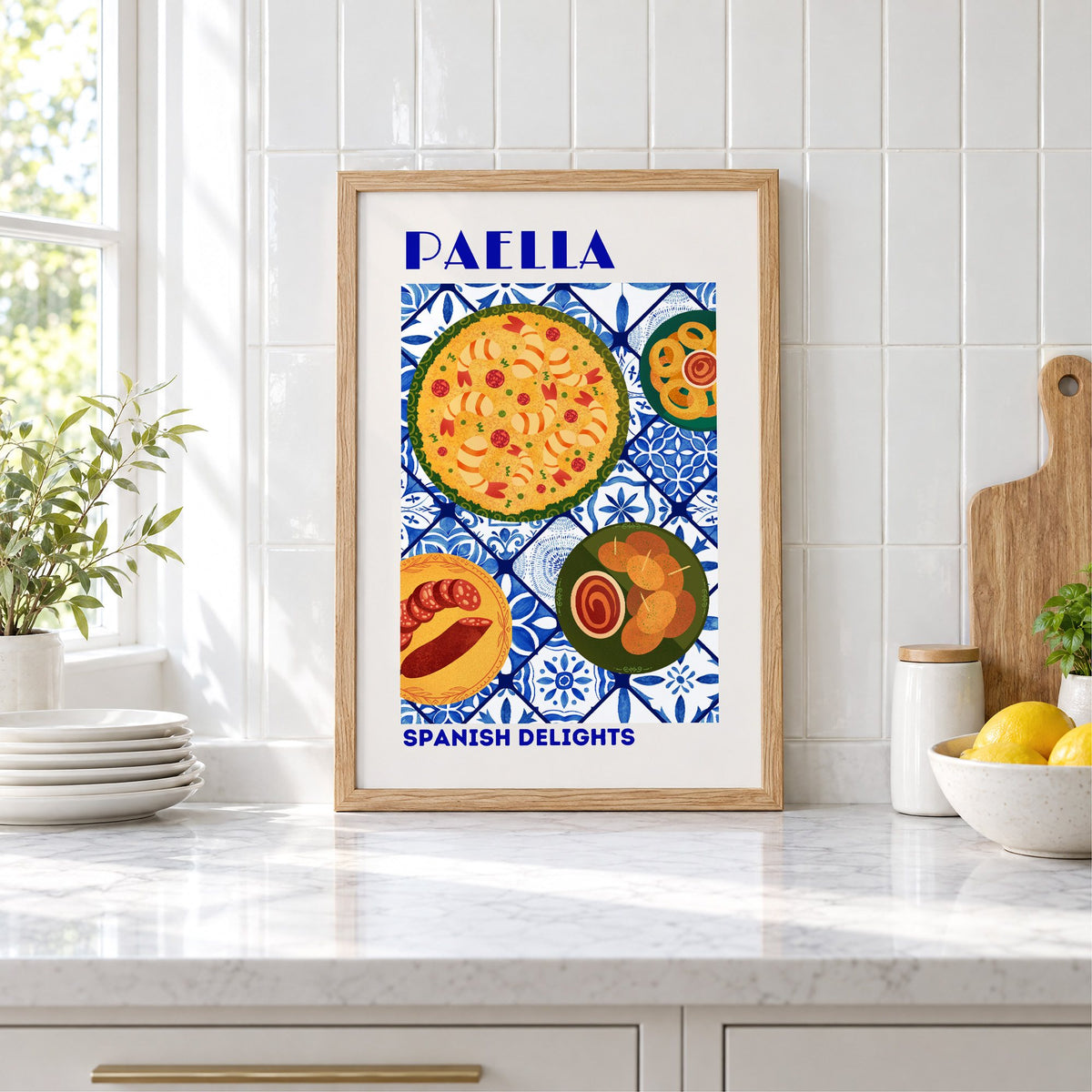 PAELLA Spanish Delights blue tile print in an oak frame leaning on a marble counter by white tiles and lemons