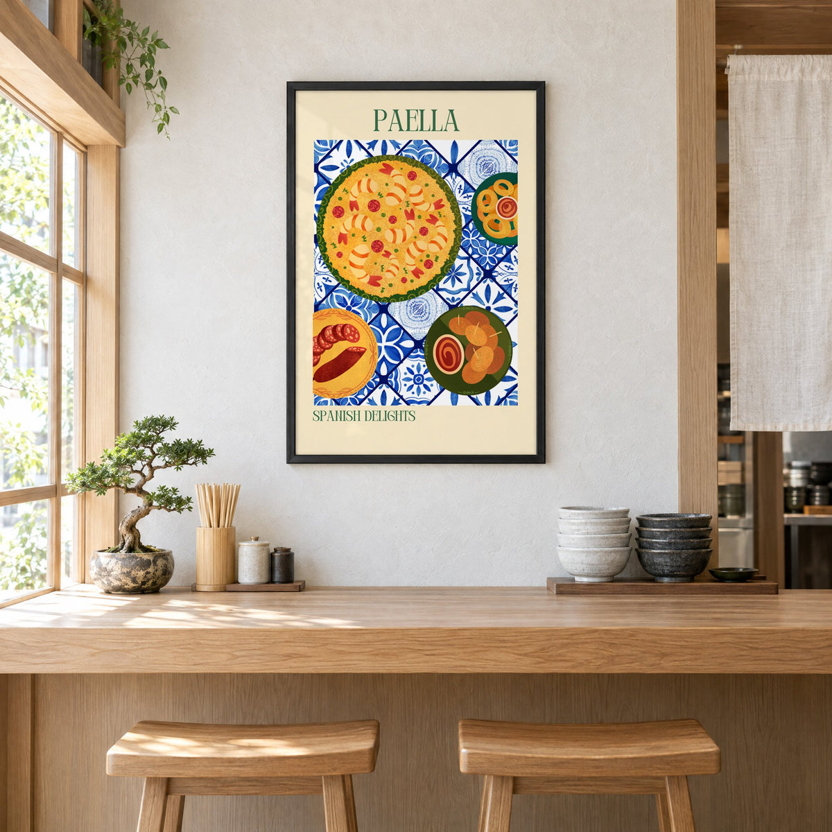 PAELLA Spanish Delights tapas tile table print in a black frame above a light wood ramen counter with stools and stacked bowls