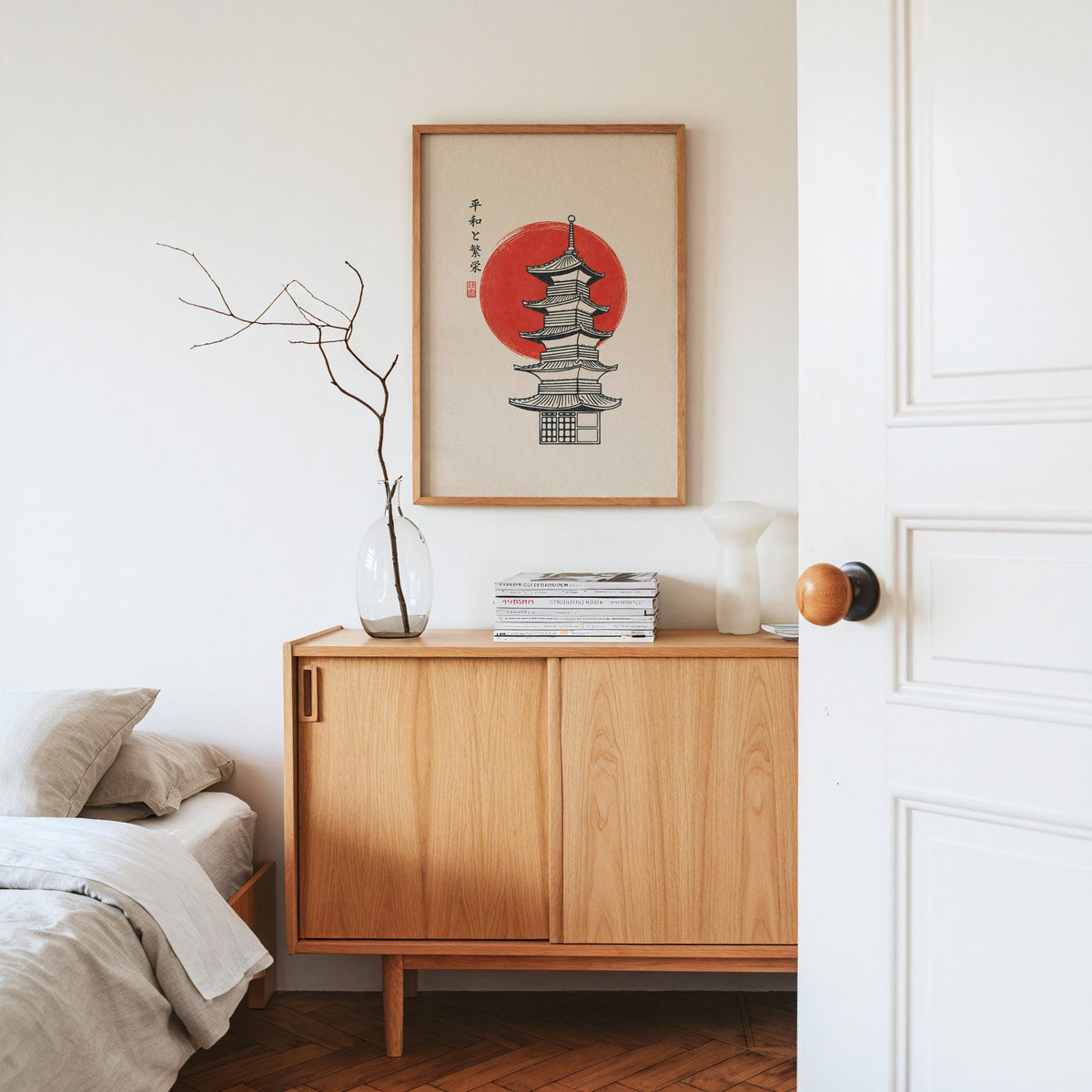 pagoda line art with red sun print in an oak frame above an oak sideboard in a bedroom with linen bedding