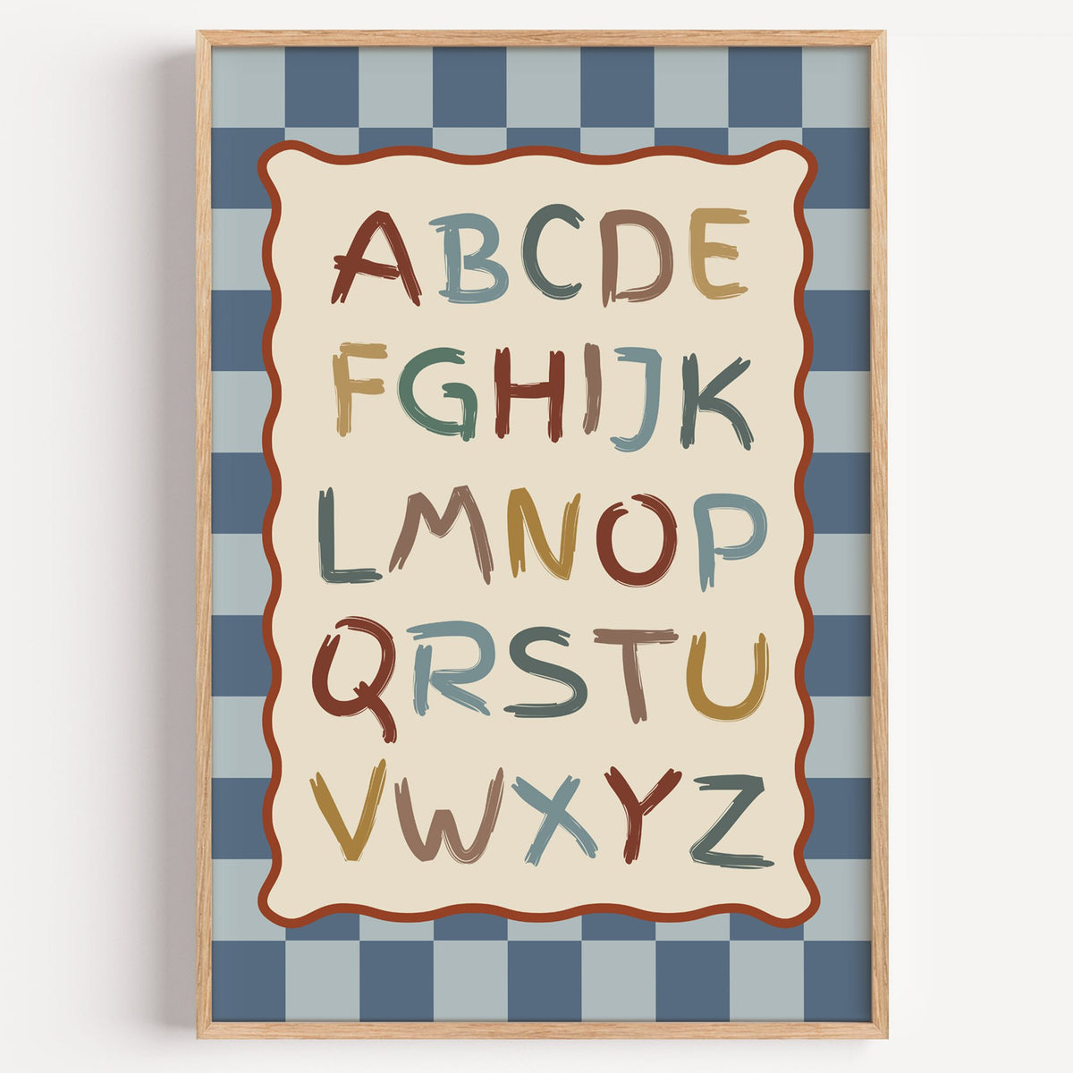 Painted alphabet wavy frame nursery print in a light oak frame on a plain white wall