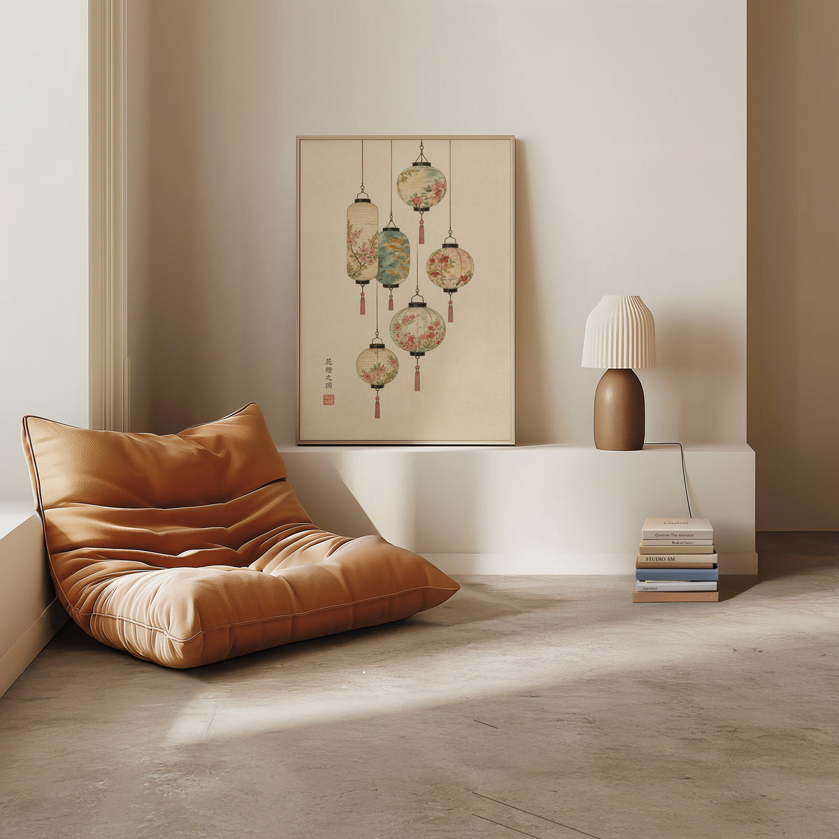 painted paper lanterns with flowers print in a light oak frame on a white ledge by a tan leather floor chair