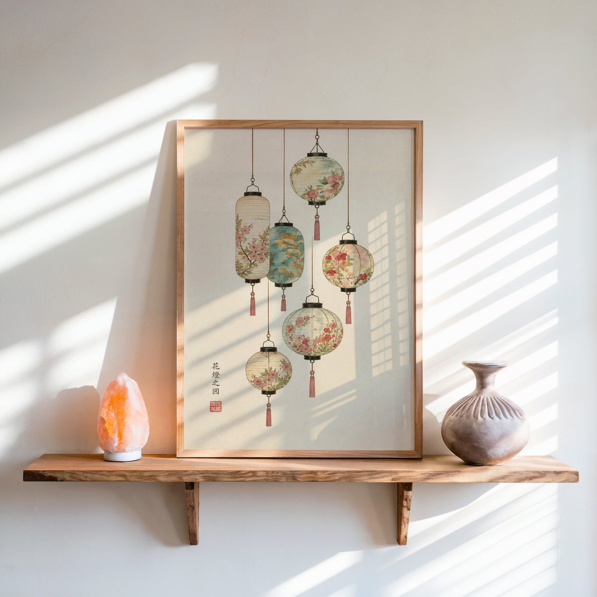 painted paper lanterns with flowers print in an oak frame on a live-edge wall shelf with a salt lamp and clay vase
