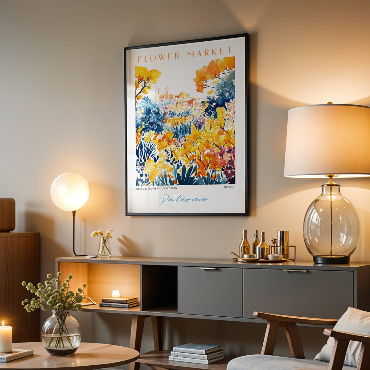 Palermo flower market print in a black frame above a grey media console with a glass table lamp