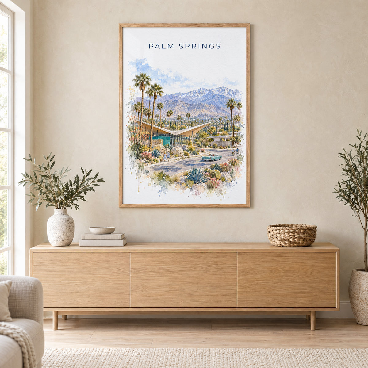 Palm Springs watercolor print in an oak frame above a light wood sideboard in a Scandinavian living room