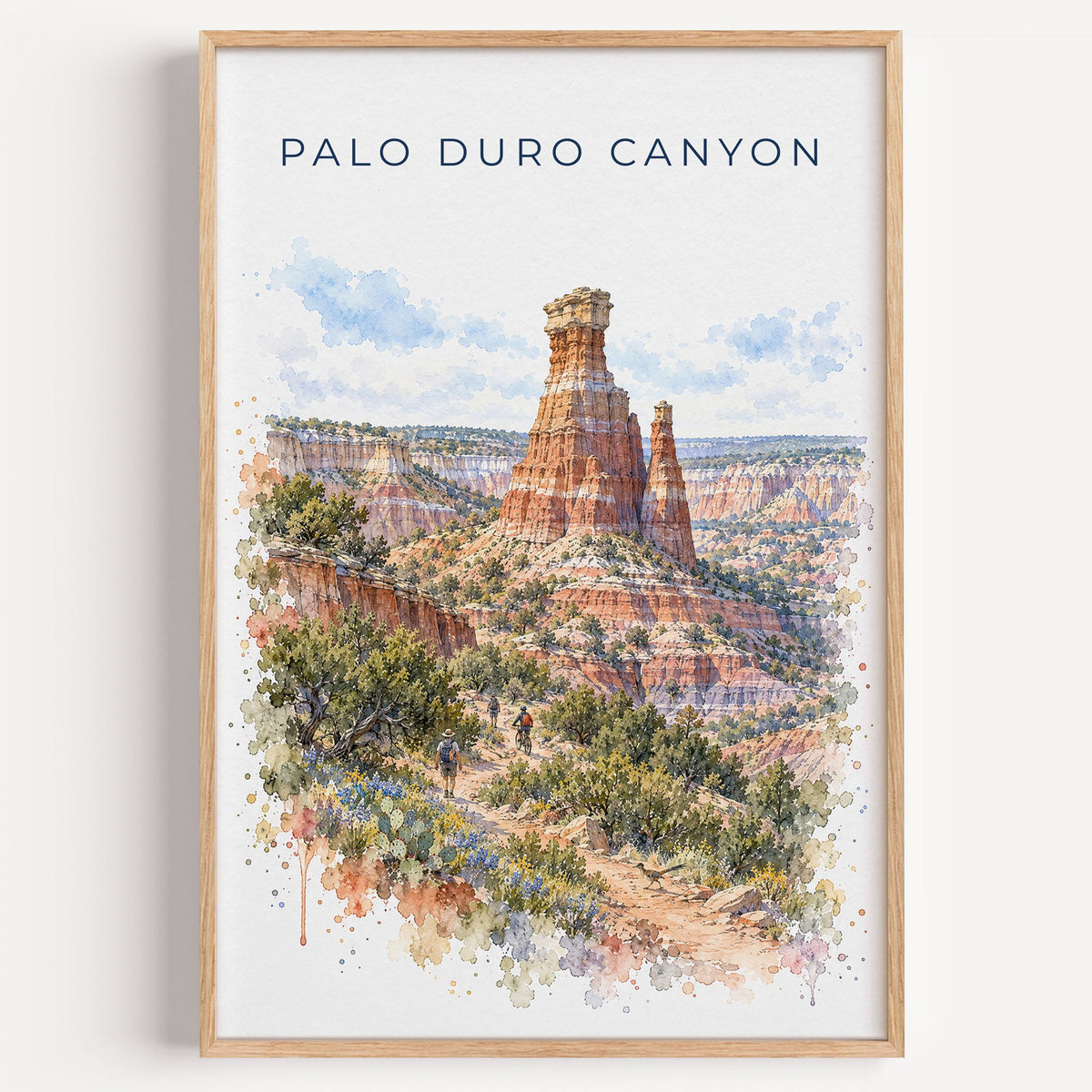 Palo Duro Canyon watercolor print in a light oak frame on a plain white wall