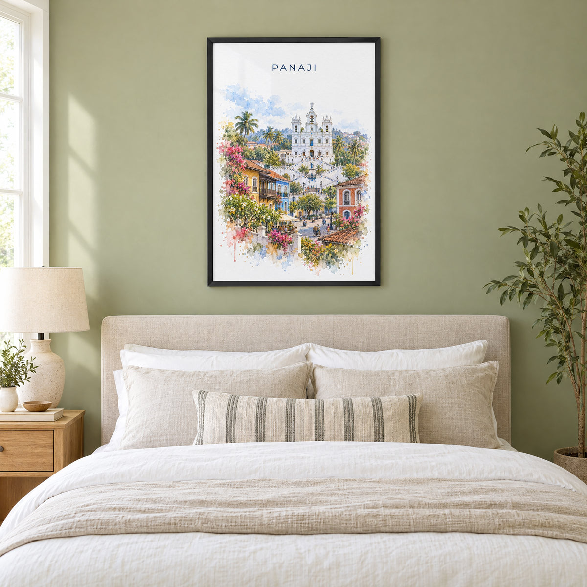 Panaji watercolor print in a black frame above an upholstered headboard in a sage green bedroom